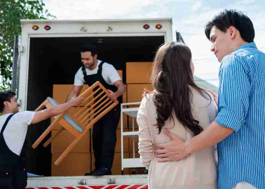 couple looking at movers carefully handle their furniture